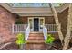 Inviting front porch with brick steps, white railings, a navy blue door, and colorful potted plants at 196 John Waites Ct., Georgetown, SC 29440