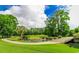 Scenic golf course with lush green landscape, pond, and bridges surrounded by mature trees under a partly cloudy sky at 2000 N Ocean Blvd. # Ph 15, Myrtle Beach, SC 29577
