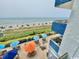 Gorgeous beach view with colorful umbrellas, tables, and lounge seating from an elevated balcony at 2001 S Ocean Blvd. # 303, Myrtle Beach, SC 29577