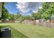 Fenced backyard with a grassy lawn, mature trees, and neighboring houses in a residential neighborhood at 2004 Seitter St., Georgetown, SC 29440