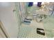 Retro bathroom with light green and white tile, pedestal sink, patterned shower curtain and blue bath mat at 2004 Seitter St., Georgetown, SC 29440