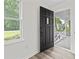Bright entryway showcasing a modern black front door and vinyl flooring with ample natural light at 203 Deer Trace, Myrtle Beach, SC 29588