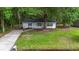 Inviting single-story home with a manicured lawn and mature trees creating a serene setting at 203 Deer Trace, Myrtle Beach, SC 29588
