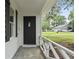 Welcoming front porch featuring a black front door, white railing, and a view of the front yard at 203 Deer Trace, Myrtle Beach, SC 29588