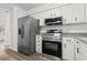Kitchen with stainless steel refrigerator, oven, microwave, white cabinets, and granite countertops at 203 Deer Trace, Myrtle Beach, SC 29588