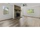 Inviting living room showcasing a stone fireplace, ceiling fan, and stylish vinyl plank flooring at 203 Deer Trace, Myrtle Beach, SC 29588