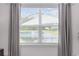 Window view showcasing a serene lake view, enhanced by neutral-toned curtains and natural light at 205 Longside Ct., Little River, SC 29566