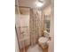 Cozy bathroom featuring a shower with floral curtain, standard toilet, and convenient towel rack at 2101 S Ocean Blvd. # A-4, North Myrtle Beach, SC 29582