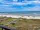 Scenic beach view with boardwalk access and distant ocean horizon under a bright blue sky at 2101 S Ocean Blvd. # A-4, North Myrtle Beach, SC 29582