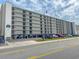 Condominium exterior showing multiple floors with parking and street view under cloudy sky at 2101 S Ocean Blvd. # A-4, North Myrtle Beach, SC 29582