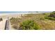 Scenic beach access with wooden boardwalk overlooking the ocean, sand dunes, and natural vegetation at 213 Westleton Dr. # 16B, Myrtle Beach, SC 29572