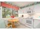 Well-lit kitchen features white cabinetry, modern appliances, and a charming breakfast table at 213 Westleton Dr. # 16B, Myrtle Beach, SC 29572