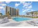 Large outdoor pool featuring comfortable lounge chairs with a high rise building and blue skies at 213 Westleton Dr. # 16B, Myrtle Beach, SC 29572