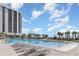 Large outdoor pool featuring comfortable lounge chairs with a high rise building and blue skies at 213 Westleton Dr. # 16B, Myrtle Beach, SC 29572