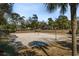 Outdoor volleyball court surrounded by trees, featuring well-maintained sand and clear skies, perfect for recreation at 213 Westleton Dr. # 16B, Myrtle Beach, SC 29572