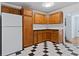 Spacious kitchen featuring wood cabinets, white appliances, and checkered tile flooring at 218 Waccamaw Village Dr. # 218, Myrtle Beach, SC 29579