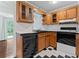 Quaint kitchen featuring wood cabinets, checkered tile floor, and black appliances at 218 Waccamaw Village Dr. # 218, Myrtle Beach, SC 29579