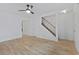 Open-concept living room with wood-look floors, ceiling fan, and access to staircase and other rooms at 218 Waccamaw Village Dr. # 218, Myrtle Beach, SC 29579