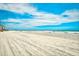 Wide sandy beach with ocean view, blue skies, and distant buildings at 2310 N Ocean Blvd. # 1107, Myrtle Beach, SC 29577