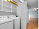 Laundry room with washer, dryer, and shelving with a view of the living room at 238 Stonebrook Dr., Myrtle Beach, SC 29588