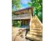 Exterior view of elevated beach house showing covered parking and wooden stairs, in a wooded setting at 2419 Hilton Dr., North Myrtle Beach, SC 29582