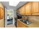 Cozy kitchen featuring stainless steel sink and cabinetry with view to bedroom at 3000 N Ocean Blvd. # 333, Myrtle Beach, SC 29577
