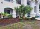 Beautiful building entrance with well-kept landscaping featuring mulch and palm trees at 330 S Middleton Dr. # 603, Calabash, NC 28467