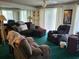 Living room featuring dark brown sectional, reclining chairs, ceiling fan, and bright natural light at 330 S Middleton Dr. # 603, Calabash, NC 28467