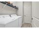 Functional laundry room with appliances, storage shelving and tiled floor at 35 Delray Dr. # 3A, Murrells Inlet, SC 29576