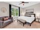 Cozy main bedroom with a plush bed, decorative pillows, seating area, and a view of lush trees at 35 Delray Dr. # 3A, Murrells Inlet, SC 29576