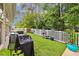 Backyard featuring a white fence, artificial grass, a grill, and a variety of potted plants at 356 Lakeside Crossing Dr., Conway, SC 29526