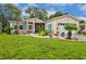 Well-maintained home with vibrant turquoise shutters, a screened-in porch, and lush tropical landscaping at 356 Lakeside Crossing Dr., Conway, SC 29526