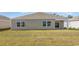 A view of the backyard featuring a well-maintained lawn and the home's exterior with windows at 3583 Ashridge Way, Conway, SC 29526