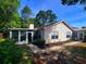The rear exterior of the home features an enclosed porch and a brick paver patio, surrounded by mature trees at 3904 Williamson Circle, Myrtle Beach, SC 29579