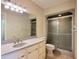 Bathroom featuring vanity with white cabinets, a solid surface counter, and a shower with a glass door at 3904 Williamson Circle, Myrtle Beach, SC 29579