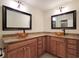 This bathroom boasts dual vessel sinks atop granite countertops, with framed mirrors and warm-toned wood cabinetry at 3904 Williamson Circle, Myrtle Beach, SC 29579