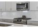 Close-up of modern stainless steel gas cooktop and microwave in a neutral kitchen at 4206 Falls Oaks St., Myrtle Beach, SC 29579