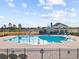 Beautiful community pool with a view of the clubhouse, picnic tables, and lounge seating at 4206 Falls Oaks St., Myrtle Beach, SC 29579