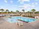 Beautiful community pool with comfortable lounge chairs and tropical landscaping on a sunny day at 4206 Falls Oaks St., Myrtle Beach, SC 29579