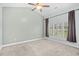 Light and airy bedroom with plush carpet, modern ceiling fan, and large window with shutters at 4767 Wild Iris Dr. # 203, Myrtle Beach, SC 29579