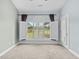 Bright bedroom featuring neutral carpet, large window with shutter, and view to the backyard at 4767 Wild Iris Dr. # 203, Myrtle Beach, SC 29579