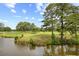 Picturesque golf course landscape featuring a tranquil pond reflecting the sky and surrounding trees on a sunny day at 4767 Wild Iris Dr. # 203, Myrtle Beach, SC 29579