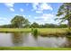 Serene view of a golf course with a pond, showcasing manicured greens and mature trees under a bright, cloudy sky at 4767 Wild Iris Dr. # 203, Myrtle Beach, SC 29579