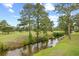 Scenic golf course view with mature trees and a flowing stream at 4767 Wild Iris Dr. # 203, Myrtle Beach, SC 29579