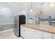 Open kitchen layout with stainless steel refrigerator and bar overlooking a bright living room at 4767 Wild Iris Dr. # 203, Myrtle Beach, SC 29579