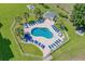 Aerial view of a sparkling community pool and surrounding landscape featuring lush lawns and palm trees at 4890 Luster Leaf Circle # 201, Myrtle Beach, SC 29577