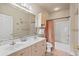 Well-lit bathroom featuring a double vanity, bathtub with shower, and peach colored shower curtain at 4890 Luster Leaf Circle # 201, Myrtle Beach, SC 29577
