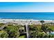 A stunning beach with clear blue water and a walkway through the palm trees, perfect for a relaxing getaway at 4890 Luster Leaf Circle # 201, Myrtle Beach, SC 29577