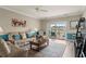 Inviting living room features a leather sofa, ceiling fan, and a sliding glass door to a private balcony at 4890 Luster Leaf Circle # 201, Myrtle Beach, SC 29577