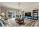 Comfortable living room has a plush sofa, ceiling fan, shelving, and access to a balcony with outdoor seating at 4890 Luster Leaf Circle # 201, Myrtle Beach, SC 29577